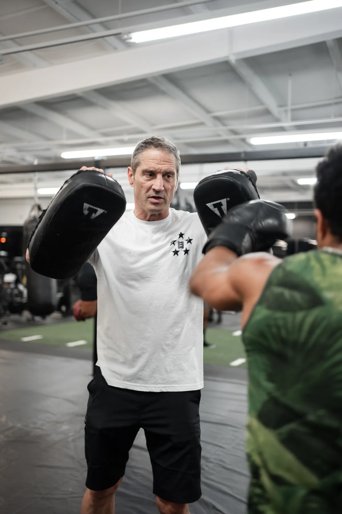 Coach holding pads for a student at Hidden Gym Richardson